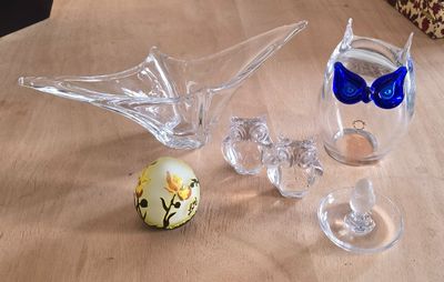 trois vases en verre posés sur une table en bois, ornés d'un nœud bleu