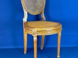 une image représentant une chaise en bois avec une assise en osier, sur fond bleu