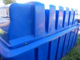 a blue trash can sitting on the grass in the yard