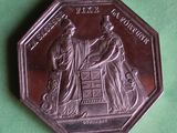 an antique silver coin with a picture of two people on it
