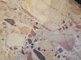 a close up of a marble table with a black chair in the background