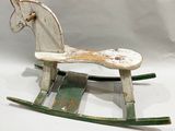 a wooden rocking horse that is sitting on a white surface