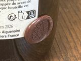 une bouteille de vin posée sur une table en bois, avec une étiquette dessus