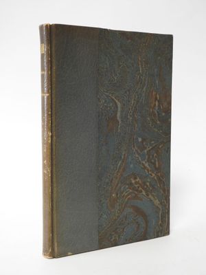 an old book sitting on top of a white table next to a white wall