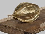 une feuille d'or posée sur une table en bois