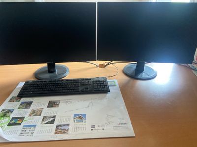 two monitors and a keyboard sitting on a desk