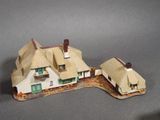 a small model of a house with a thatched roof
