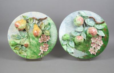 two plates with fruit and flowers painted on them sitting on a table