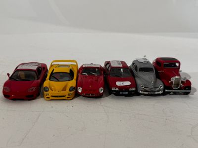 several toy cars are lined up in a row on a white surface
