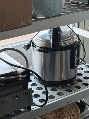 un mixeur argenté et noir posé sur une étagère dans une cuisine