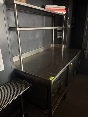 une cuisine équipée de plans de travail et d'étagères en acier inoxydable