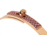 a gold bracelet with pink crystals on a white background