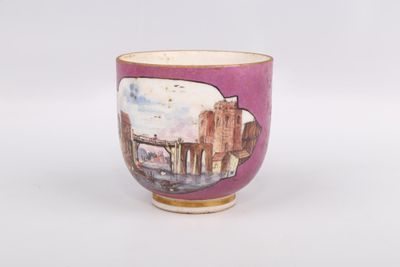 une tasse violette sur laquelle est représentée une ville