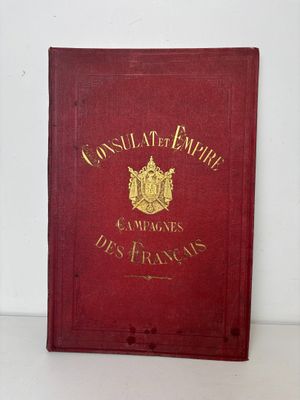 un vieux livre rouge orné de lettres dorées, posé sur une surface blanche