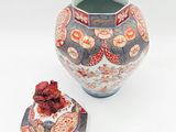 a small vase and a small box on a white surface