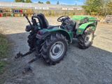 a green tractor that is parked on the side of the road