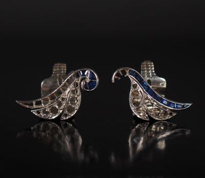 a pair of blue and white sapphire earrings on a black surface