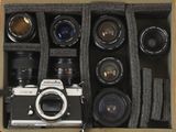 une boîte contenant un appareil photo et plusieurs objectifs