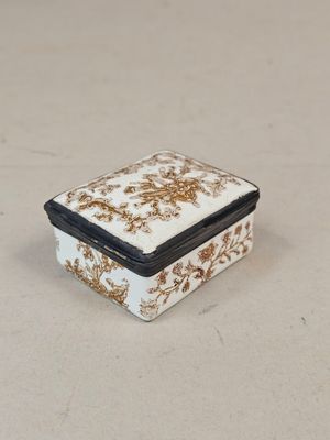 Une boite à pilules rectangulaire en métal émaillé blanc à l…