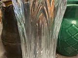 a glass vase sitting on a table next to other vases