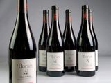 six bouteilles de vin sont alignées sur une table