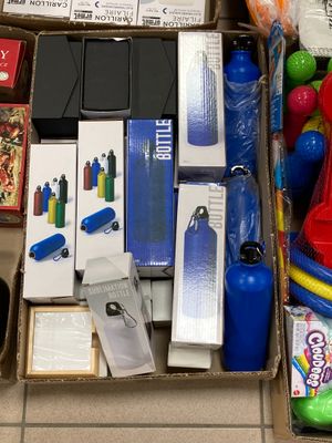 une boîte remplie de jouets et d'autres objets posée par terre