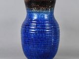 a blue vase that is sitting on a table