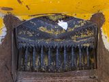 a grate in the middle of a hole in a yellow wall