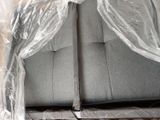 the back of a couch covered in plastic sitting on top of a hard wood floor