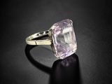 a close up of a ring with an amethorate stone on a black surface