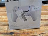 La boîte de la manette PlayStation est posée sur la table en bois.