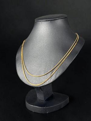 un collier à chaîne en or sur un mannequin, sur fond noir
