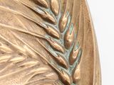 a close up of a metal plate with a plant on it