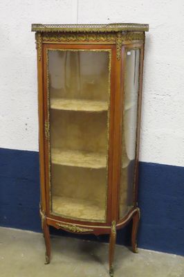 une petite armoire avec une porte vitrée, dans un coin
