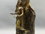une image d'une statue en bronze représentant une femme tenant un oiseau