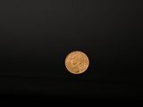 a close up of a gold coin on a black background