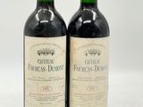 deux bouteilles de vin rouge posées l'une à côté de l'autre sur une surface blanche