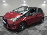 une Toyota Yaris rouge garée sur un sol à damier