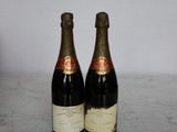 two bottles of wine sitting on top of a table next to each other