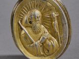 a gold medal with a picture of a man holding a sword