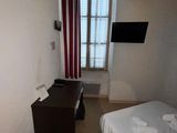 un petit lit dans une petite chambre équipée d'une télévision à écran plat