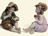 deux figurines représentant un garçon et une fille assis l'un à côté de l'autre