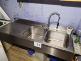 a stainless steel sink with a faucet in the corner