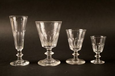 trois verres à pied en verre transparent posés les uns à côté des autres sur une surface noire