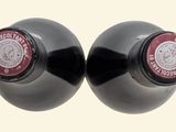 two bottles of wine sitting next to each other on a table