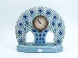 a blue and white clock sitting on a blue stand