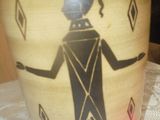 un vase orné d'une image représentant une femme, posé sur une table