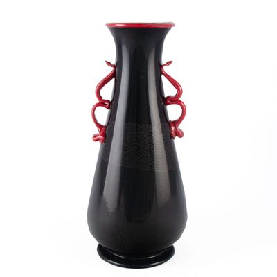 un vase noir avec une anse rouge sur fond blanc