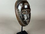 a close up of a sculpture of a face with a bird on top of it