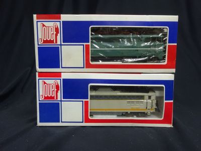 two boxed boxes of toy trains sitting on a black surface